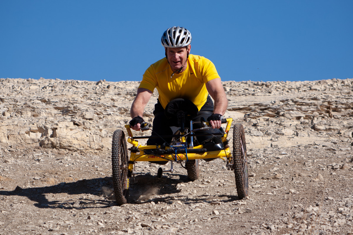 hand cyclist riding down a steep rocky hill